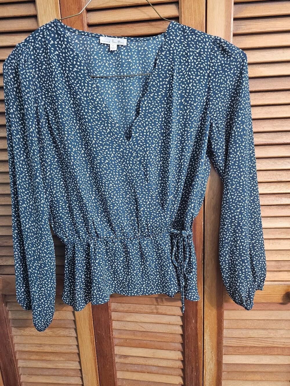 Nine Britton emerald green blouse with a white speckle pattern and a faux wrap